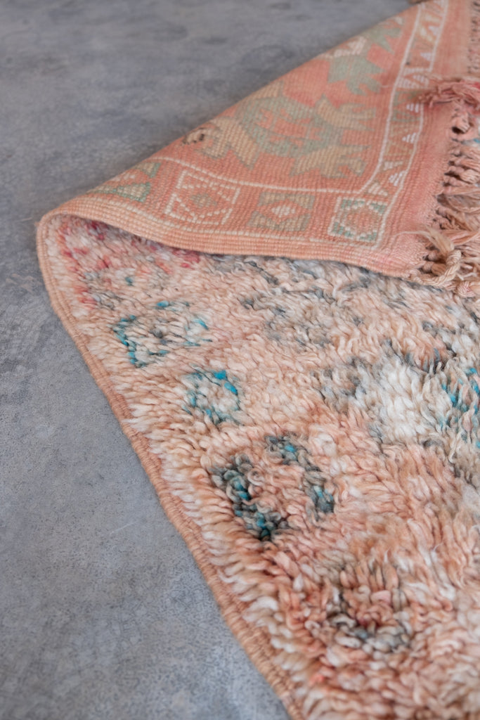 Vintage Moroccan rug displaying intricate tribal patterns.