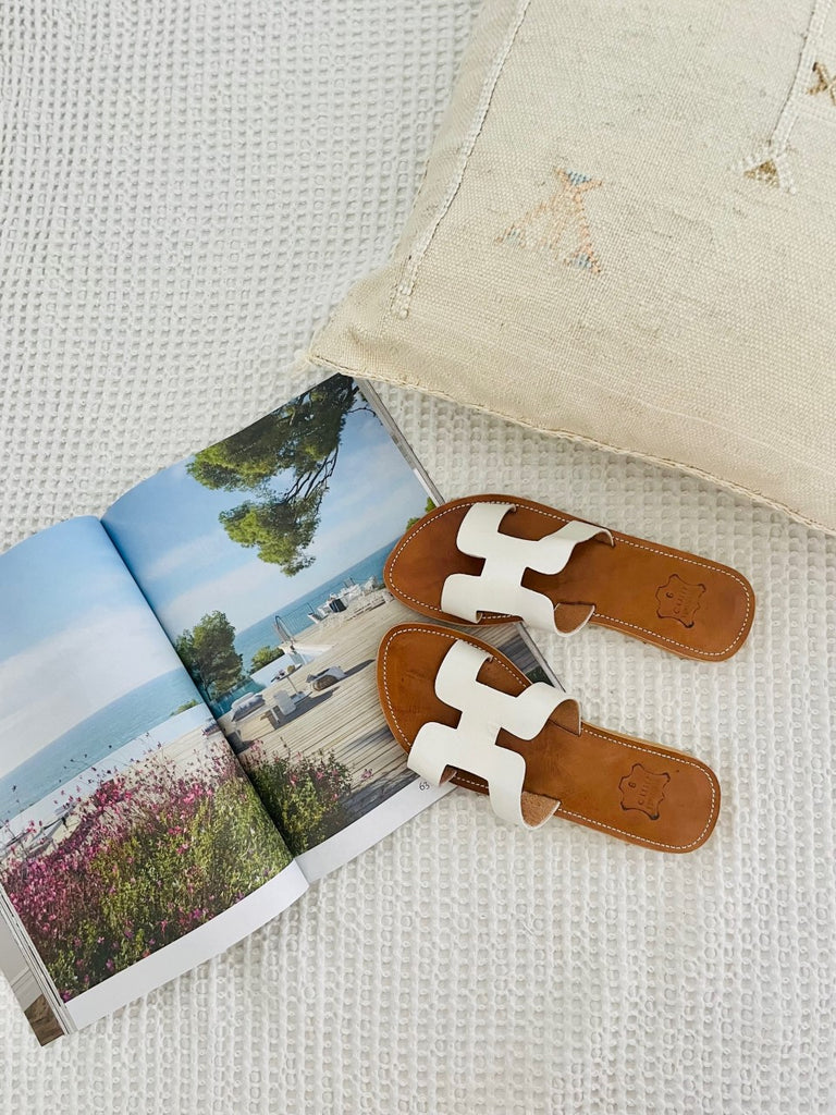White leather slides, perfect for summer shopping in Australia.